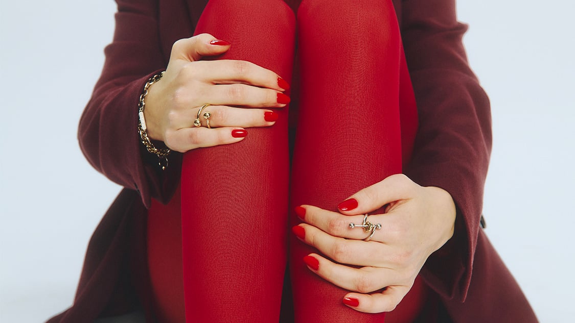 Photo focus main d'une mannequin entourant ses genoux