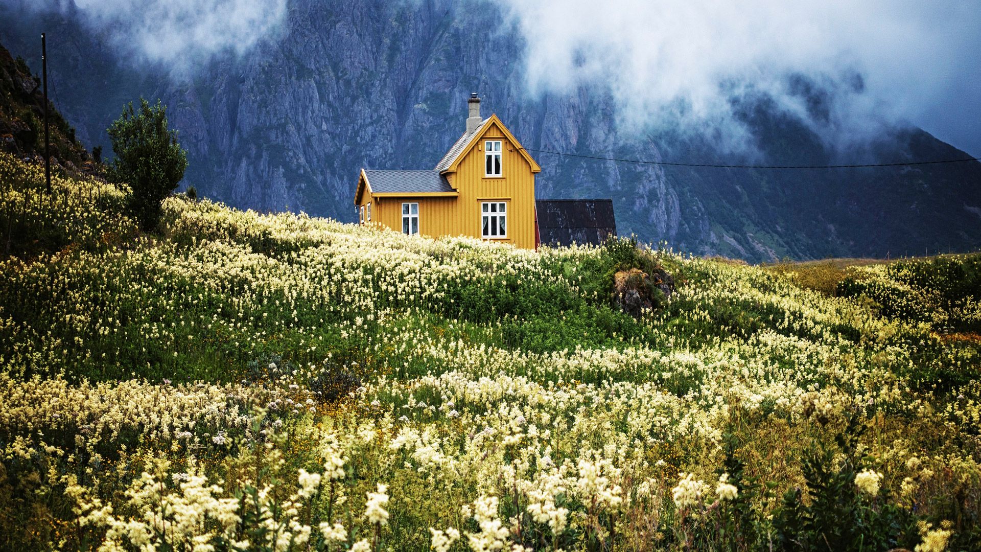 Maison jaune au milieu des montagnes
